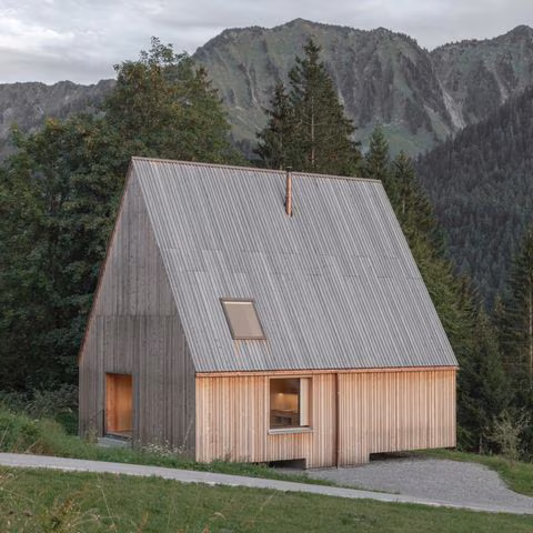 Moderne, vollständig mit Lärchenholz verkleidete Berghütte mit steilem Spitzdach