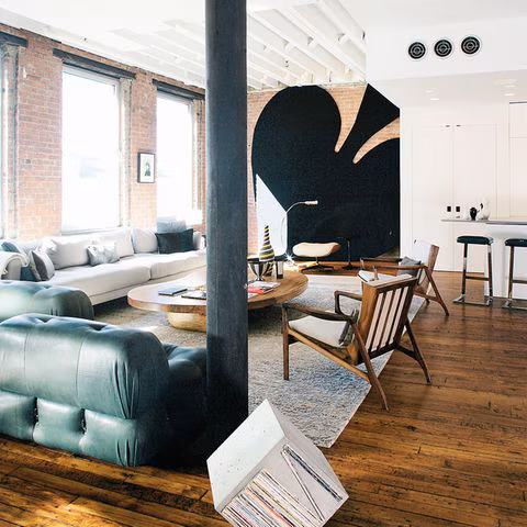 Wohnzimmer in einem Loft mit offener Backsteinwand